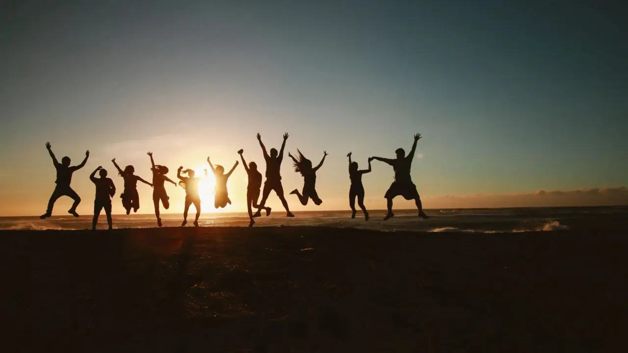 Young woman jumping on a beach at sunset