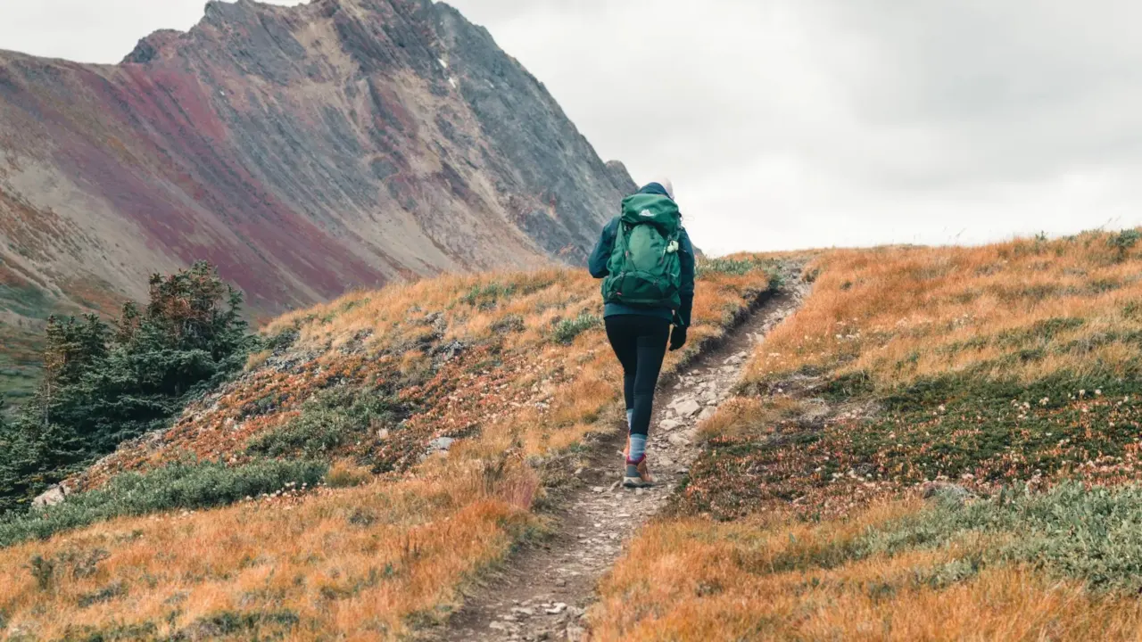Backpacker walking along a mountain trail